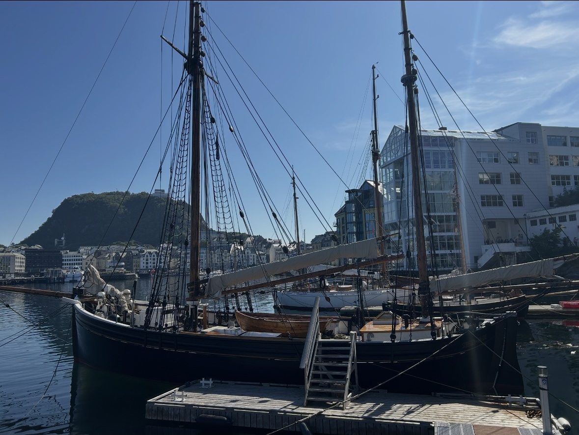 Masten historischer Segelschiffe vor der Jugendstil-Architektur Ålesunds, Norwegen