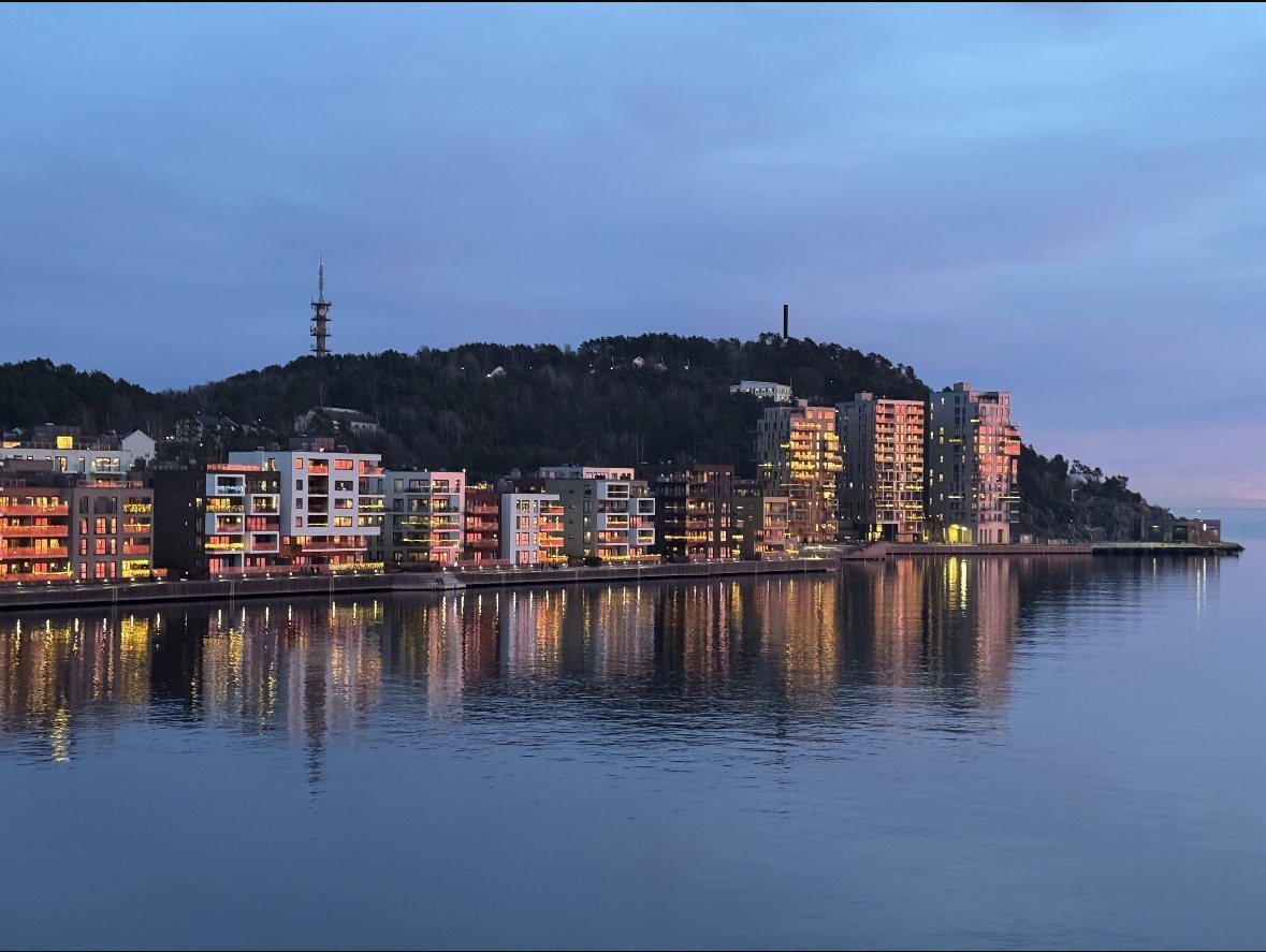 Beleuchtete moderne Wohnbebauung am Wasser in Kristiansand, Norwegen, bei Nacht