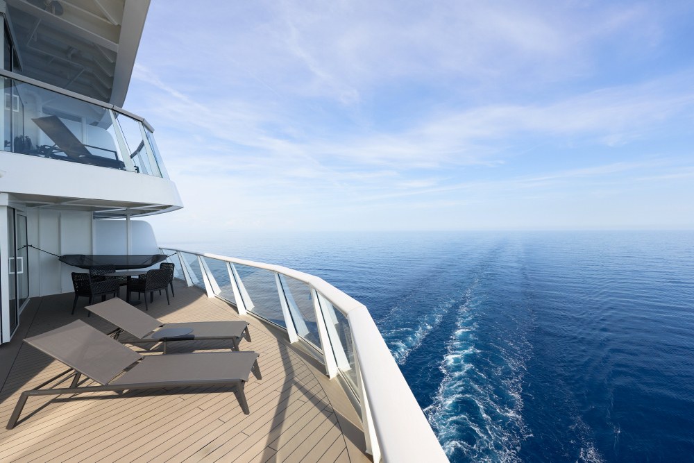 Pressefoto von TUI Cruises, Balkon einer Mein-Schiff-Kabine mit zwei Liegen und Blick auf das Kielwasser